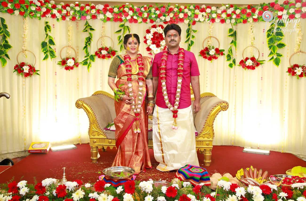 Mother-to-be in traditional South Indian attire with intricate henna and lavish jewelry at her baby shower in Chennai.