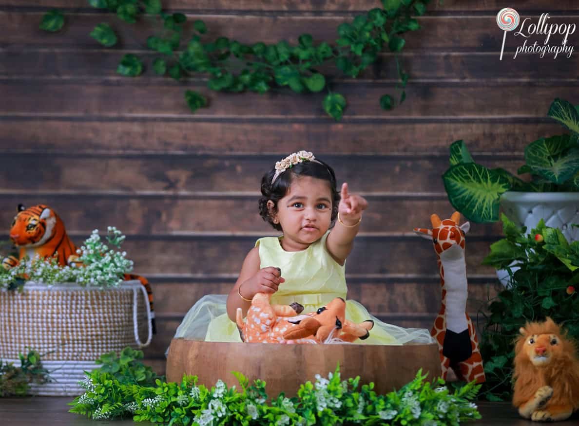 kids-indoor-studio-session-chennai Little girl engaging with jungle animal toys in a themed studio photoshoot in Chennai
