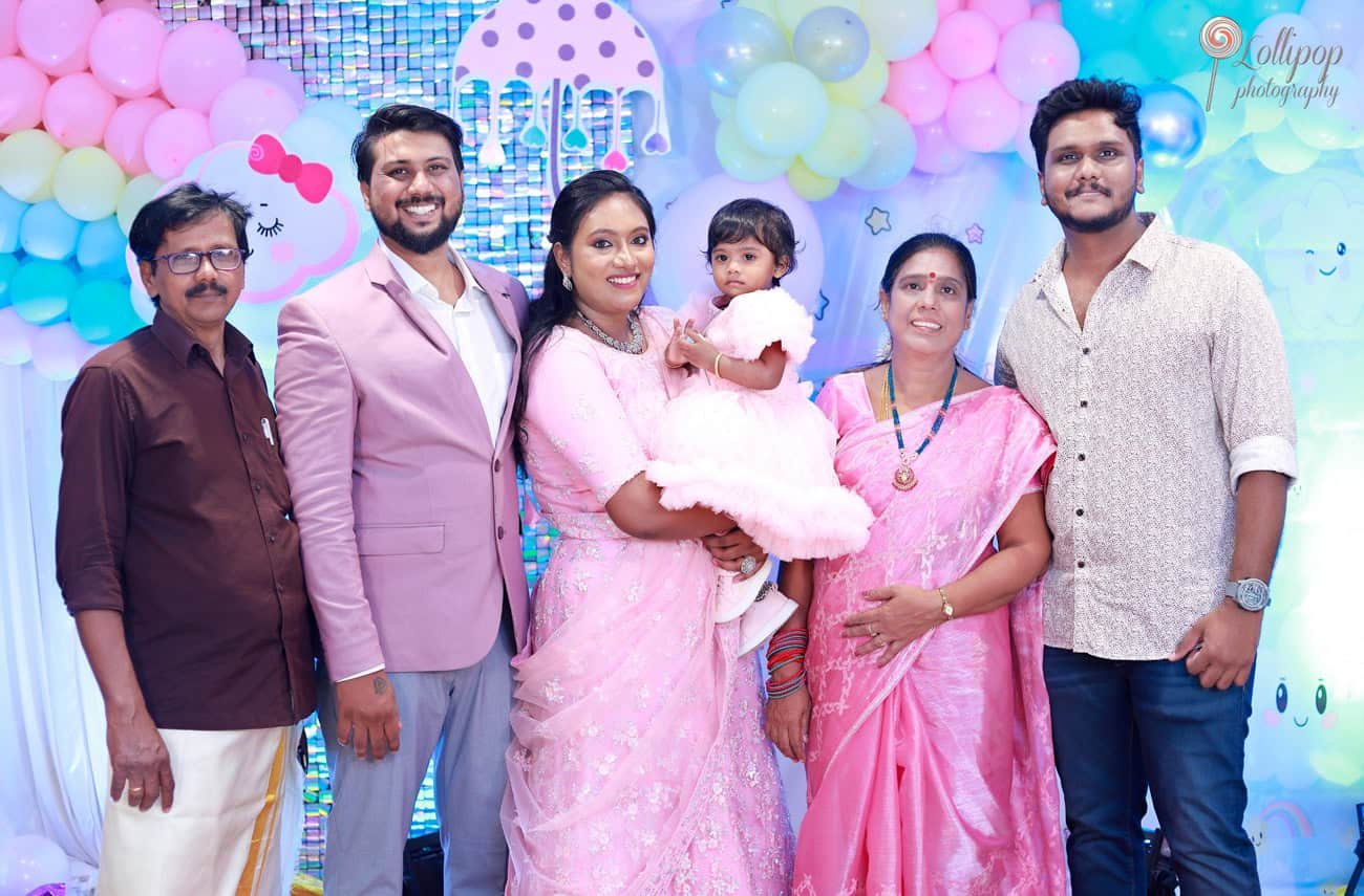 A delightful family moment as Kanali's family gathers to celebrate her birthday, with vibrant decorations and smiles all around, beautifully captured by Lollipop Photography
