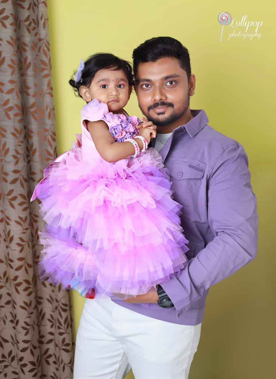 Cherished father-daughter moment as Sarah celebrates her first birthday in a beautiful rosette dress. Captured by Lollipop Photography.