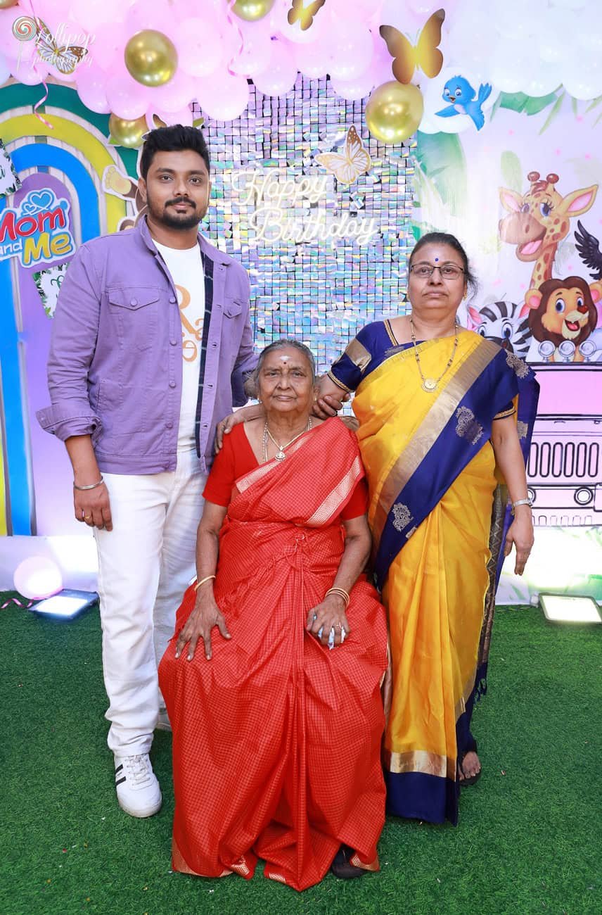 Sarah's dad stands proudly beside a colorful 'Mom and Me' backdrop, captured by Lollipop Photography