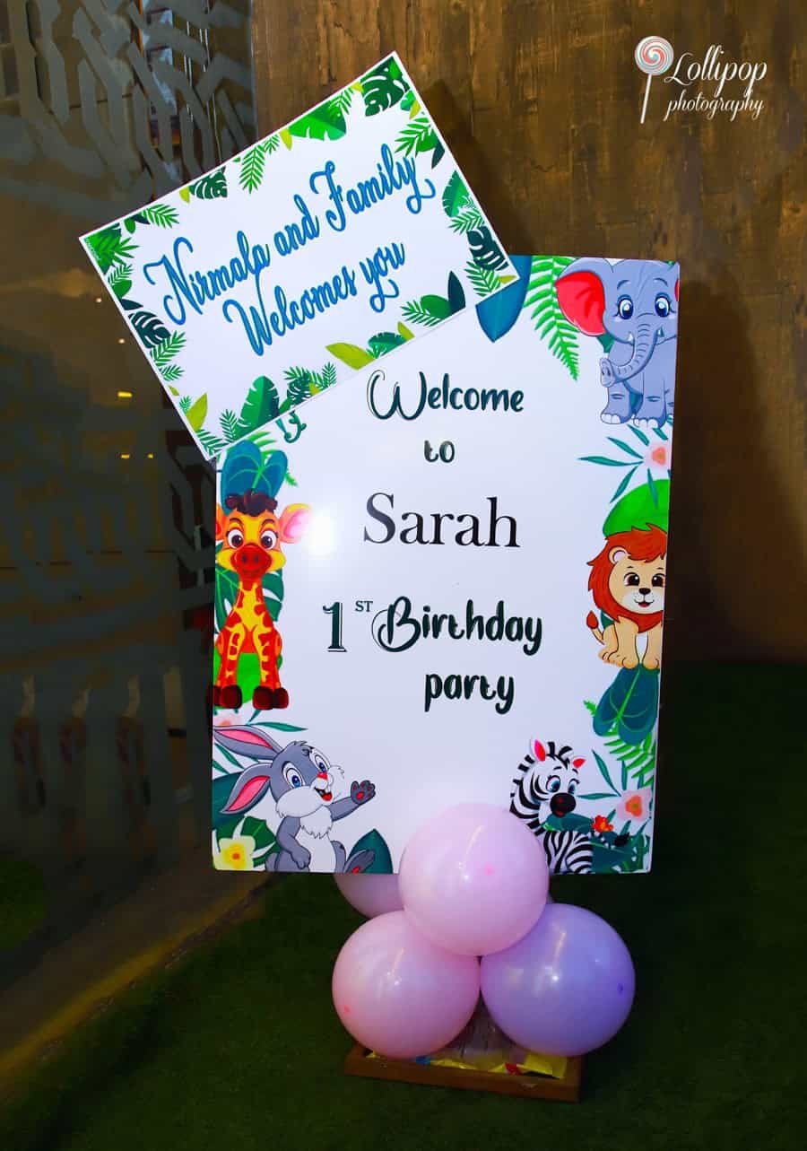 Welcome sign at Sarah's first birthday party, warmly inviting guests with jungle-themed decorations. Captured by Lollipop Photography.