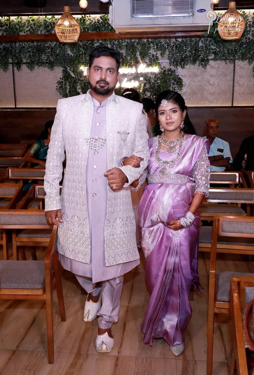 Suganthi and her husband make a grand entrance, walking hand-in-hand to their baby shower celebration