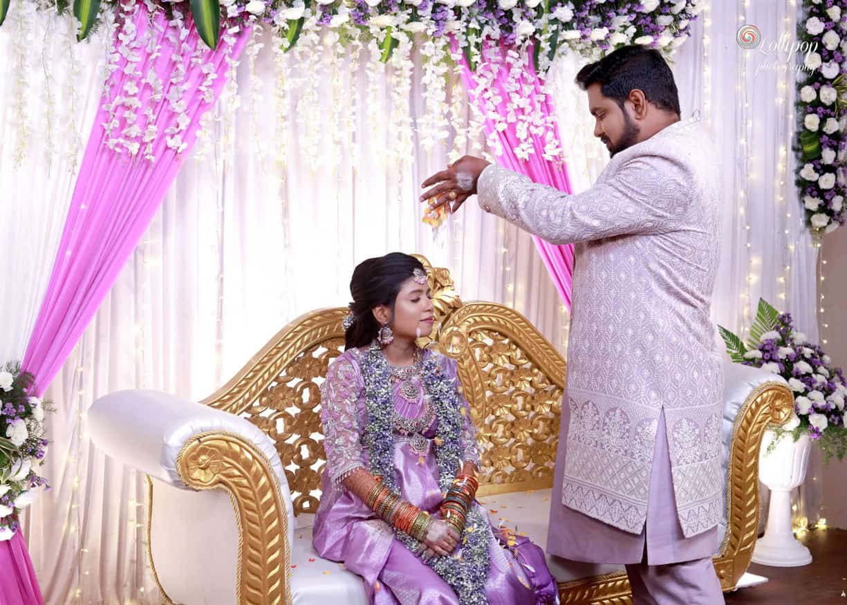 The groom gently pours floral blessings over his bride, symbolizing love and harmony at their baby shower celebration, beautifully captured by Lollipop Photography